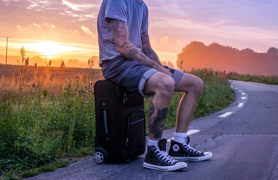 Bőröndön ül egy tetovált srác